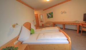 a small room with a bed and a desk at Hotel Kuchalber Hof in Donzdorf