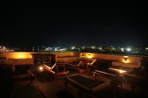 a rooftop patio at night with chairs and lights at El Mosaico Del Sol in Lampedusa