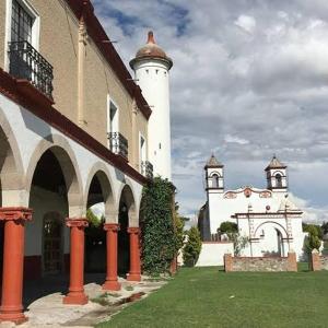 un bâtiment avec deux tours blanches dans une cour dans l'établissement Ex-Hacienda San Buenaventura, à San Lorenzo Soltepec