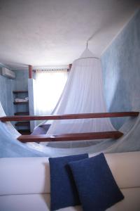 a bedroom with a bed with a white canopy at El Mosaico Del Sol in Lampedusa
