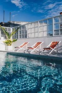 a group of chairs sitting next to the water at Borbaboom Phuket Poshtel & Hostel in Phuket Town