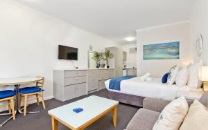 a bedroom with a bed and a living room at Glenelg Oasis Studios in Adelaide