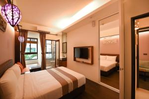 um quarto de hotel com uma cama e uma televisão em Move Resort & Spa em Anping
