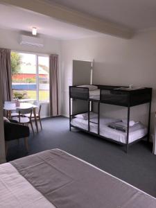 a bedroom with a bunk bed and a table and a dining room at Orford Blue Waters Hotel in Orford