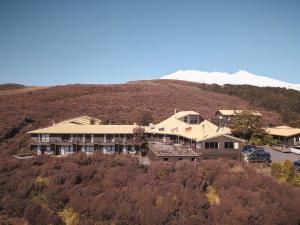 um edifício no topo de uma colina com uma montanha em Skotel Alpine Resort em Whakapapa Village