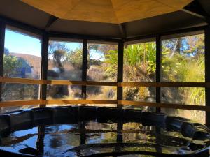 a room with a table and chairs and windows at Skotel Alpine Resort in Whakapapa Village