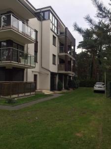 an apartment building with a car parked in the yard at RESET ul. Ratibora 66 in Jurata