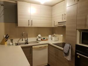 a kitchen with white cabinets and a sink at Devonport Charm house in Auckland