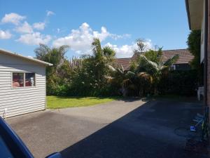a driveway in front of a house with palm trees at Devonport Charm house in Auckland