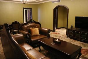 a living room with leather chairs and a television at Hohhot Level of Details in Hohhot