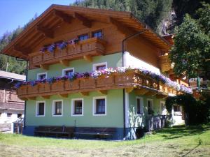 a house with a balcony with flowers on it at Ferienwohnung Heimatglück in Matrei in Osttirol
