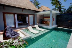 a villa with a swimming pool and a house at A Villa Gili Air in Gili Islands