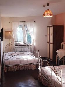 1 dormitorio con 2 camas y ventana en Austeria en Ostróda