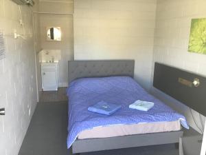a bedroom with a bed with two blue towels on it at Rankins Springs Motel in Rankins Springs