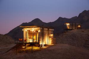 a house on a hill with mountains in the background at Hatta Resorts in Hatta