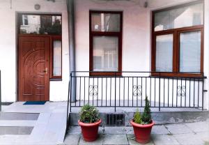 une maison avec deux plantes en pot devant une porte dans l'établissement Lviv City Apartment, à Lviv