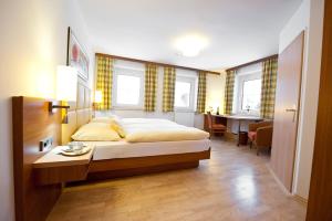 a bedroom with a bed and a desk in it at Hotel Sonnenhof in Timelkam