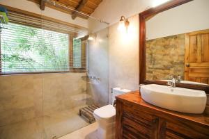 a bathroom with a sink and a shower and a toilet at Binsar Forest Retreat in Binsar
