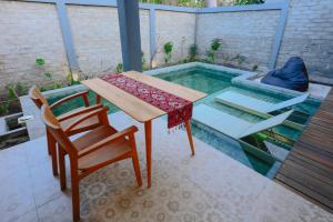 a patio with a table and chairs and a swimming pool at A Villa Gili Air in Gili Islands