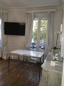 a living room with a table and a television at Anna’s Home in Troyes
