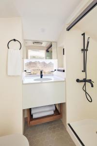 a bathroom with a white sink and a shower at Hatta Sedr Trailers Resort in Hatta