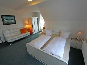 ヘリングスドルフにあるFerienappartements Heringsdorf USEのベッドルーム1室(ベッド2台、ソファ付)