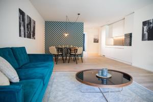 uma sala de estar com um sofá azul e uma mesa em Gubelhof Suites em Zug