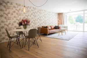 uma sala de estar com um sofá, uma mesa e cadeiras em Gubelhof Suites em Zug