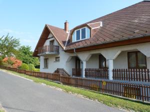 ボニャルツバシュにあるHorizont Nyaralóházの褐色の屋根と柵の白い家