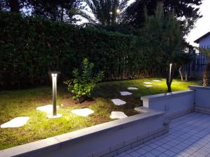 um jardim com duas luzes na relva em The Great Beauty Apartment em Bordighera