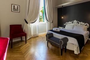 a bedroom with a large bed and a red chair at Mediterraneo Emotional Hotel & Spa in Santa Margherita Ligure