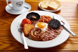 a plate of breakfast food on a wooden table at Trearddur Bay Hotel in Trearddur