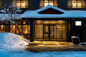 a building with snow on the front of it at Meitoya So in Zao Onsen