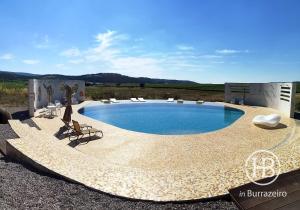 una gran piscina con sillas en Herdade do Burrazeiro en Borba