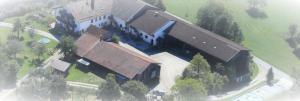 una vista aérea de una casa grande con un techo grande en Bio Kinder Erlebnis Bauernhof Voit en Söchtenau