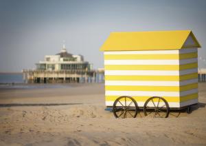 Une cabane de plage jaune et blanche sur la plage dans l'établissement Apartment Helena 4, à Blankenberge