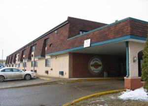 un bâtiment avec une voiture garée sur un parking dans l'établissement Colonial Inn, à Brandon