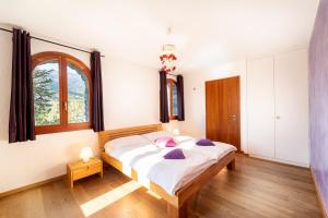 a bedroom with a large bed and a window at Castel de Daval in Sierre