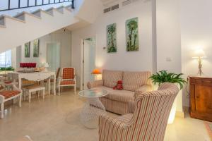 un soggiorno con 2 sedie e un tavolo di Espectacular apartamento con terraza privada parking a Siviglia