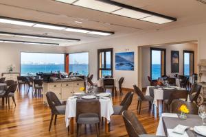 a restaurant with tables and chairs and the ocean in the background at Hotel El Mirador de Fuerteventura in Puerto del Rosario