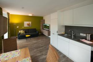 a kitchen and a living room with a couch at Appartements Marlene in Maishofen