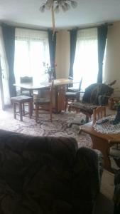uma sala de estar com um sofá, uma mesa e janelas em Vila Nature - Rosia Montana em Aktenburg