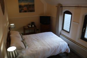 ein Schlafzimmer mit einem weißen Bett und einem Fenster in der Unterkunft Victoria House in Barrow in Furness