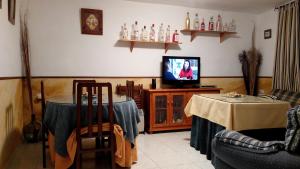 カサジャ・デ・ラ・シエラにあるBarrio Nuevoのリビングルーム(テレビ、テーブル、椅子付)