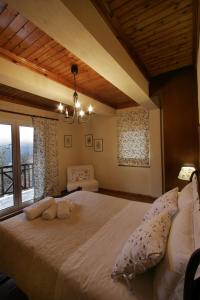 1 dormitorio con 1 cama grande y ventana grande en Villa Filokosta, en Pertouli