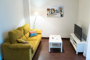 セビリアにあるApartamento Los Azaharesのリビングルーム(黄色のソファ、テレビ付)