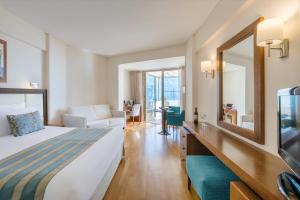 a hotel room with a bed and a mirror at Golden Bay Beach Hotel in Larnaca