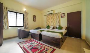 a hotel room with two beds and a window at Treebo Trend Ivory House in Nagpur