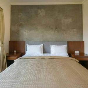 una camera da letto con un grande letto con due cuscini di Arnaya Homestay a Kuta