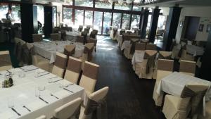 a dining room with white tables and chairs at Hotel Simpo Pržar in Vranje